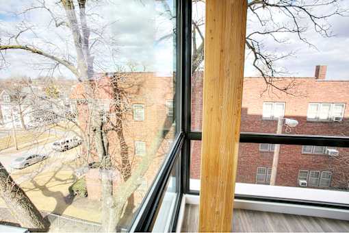 A view from a window looking out at a parking lot and buildings.