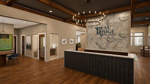 A reception area for Real Ridge Village Community with a stone backdrop and a black reception desk.