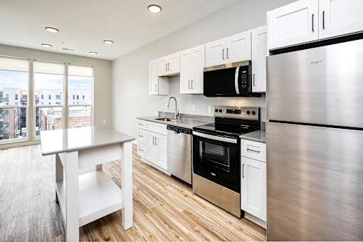 A modern kitchen with stainless steel appliances and white cabinetry.