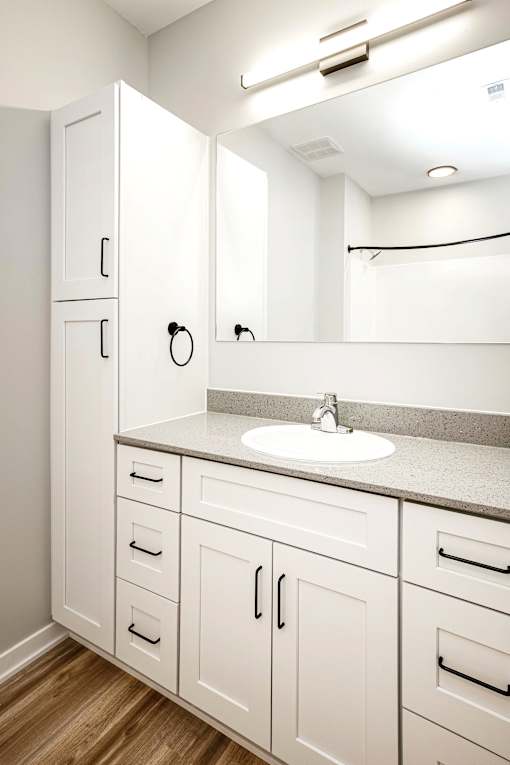 A bathroom with a sink and cabinets.