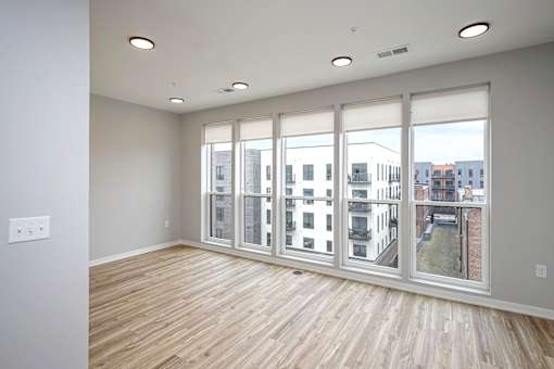 A room with a large window and wooden flooring.