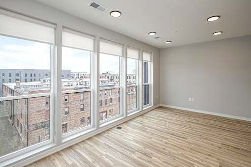 A room with a view of a cityscape through large windows.