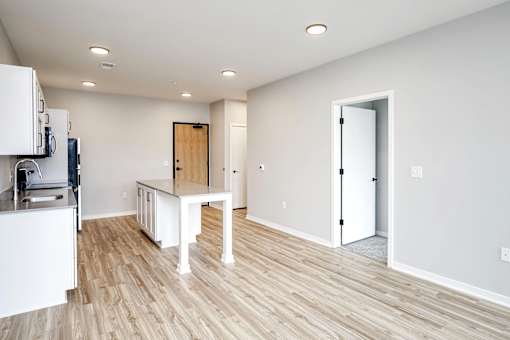 A kitchen with white cabinets and a wooden door.