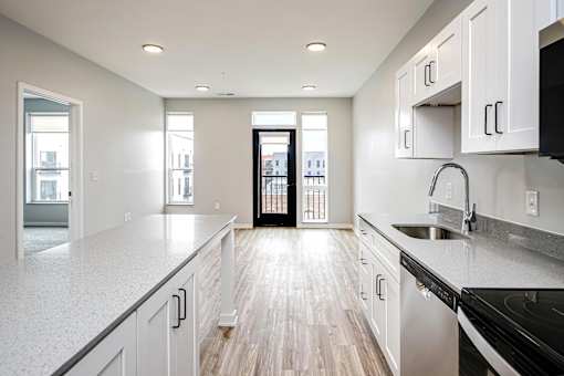 A kitchen with white cabinets and a black stove top oven.