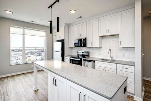 A kitchen with white cabinets and a large island.