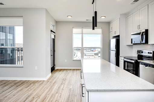 A modern kitchen with white cabinets and black appliances.