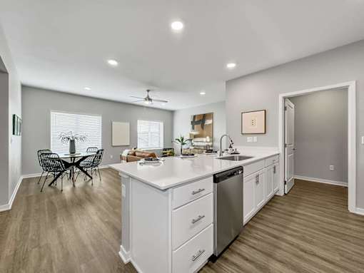 A modern kitchen with a dining table and chairs.
