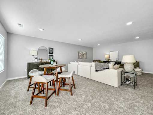 A living room with a grey carpet and furniture.