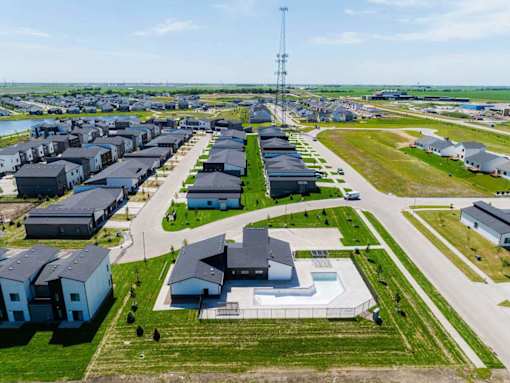 A large community with a swimming pool and a cell tower in the background.