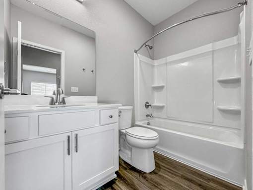 A white bathroom with a toilet, sink, and bathtub.