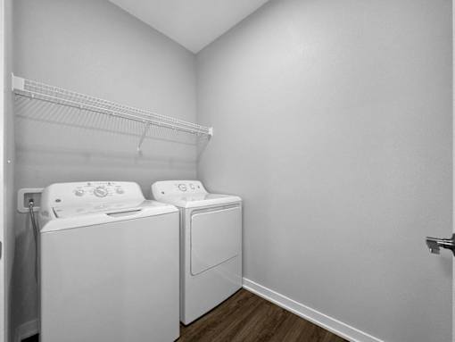 Two white front load washing machines in a laundry room.