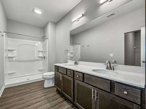 A bathroom with a white toilet, a sink, and a mirror.