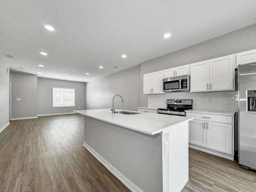 A kitchen with white cabinets and a white countertop.