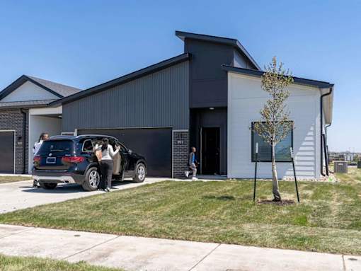A modern house with a car parked in front.