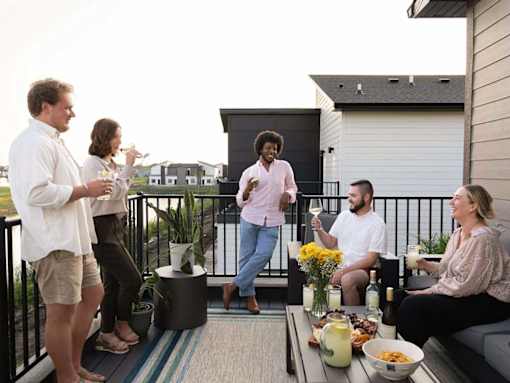 A group of people are gathered on a balcony for a social event.
