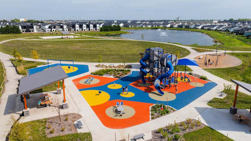 A playground with a blue and yellow slide and a red and white slide.