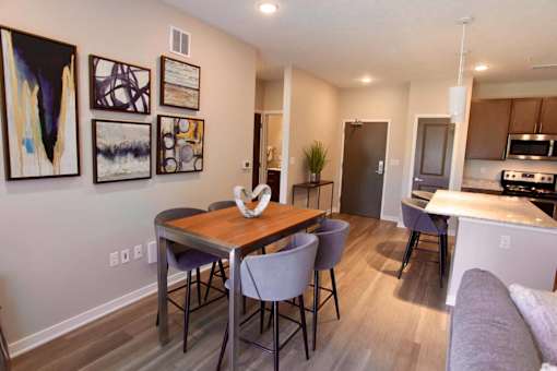 A dining room with a table and chairs.