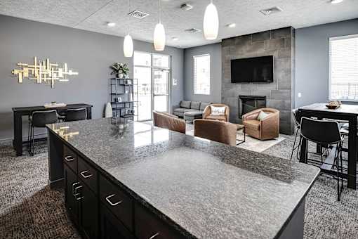 A modern kitchen with a large island and a fireplace in the living room.