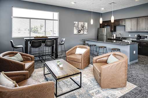 A modern living room with brown leather chairs and a glass coffee table.