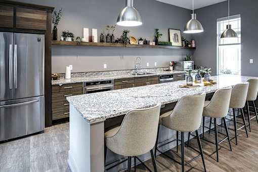 A kitchen with a marble countertop and modern appliances.