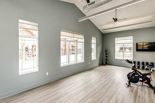 A spacious room with a stationary bike in the corner.