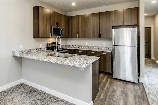A kitchen with a granite countertop and stainless steel appliances.