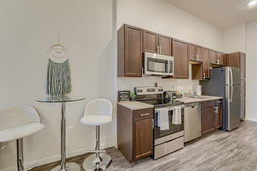 A kitchen with a white chair and a glass table.