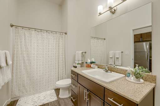 A bathroom with a white toilet, sink, and shower curtain.