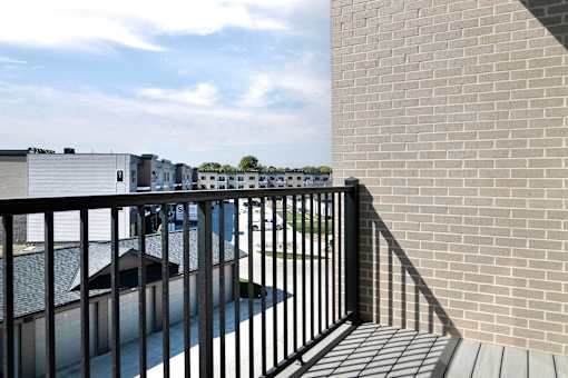 a balcony with a brick wall and a black railing