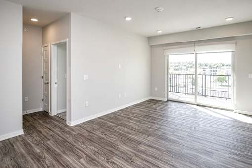 an empty living room with a door to a balcony