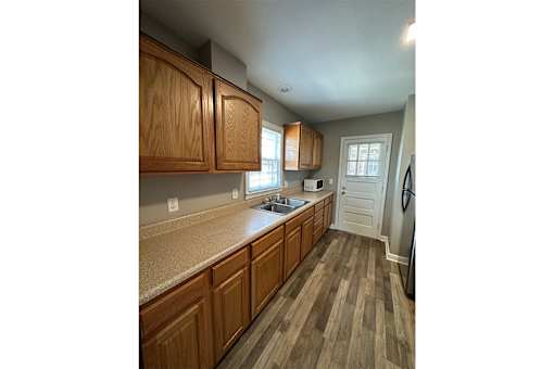 A kitchen with wooden cabinets and a white refrigerator.