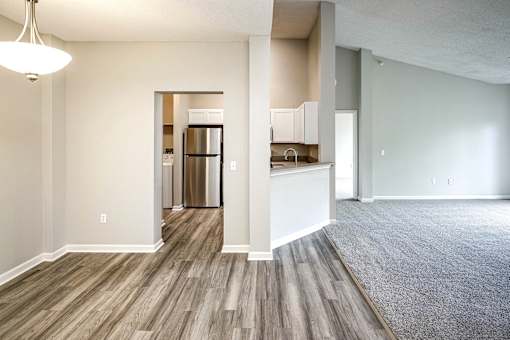 an empty living room and kitchen with wood flooring at Autumn Grove Apartments, Omaha, NE