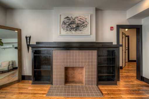 A fireplace with a black mantle and a framed picture above it.