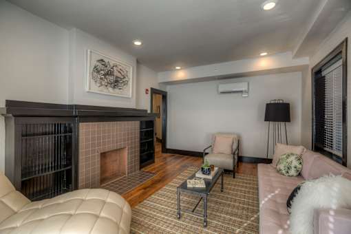 A living room with a fireplace and a painting on the wall.