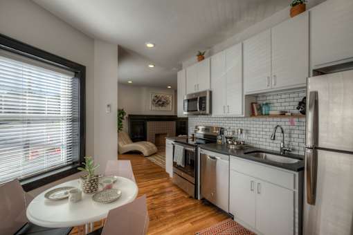 A modern kitchen with a table and chairs by the window.