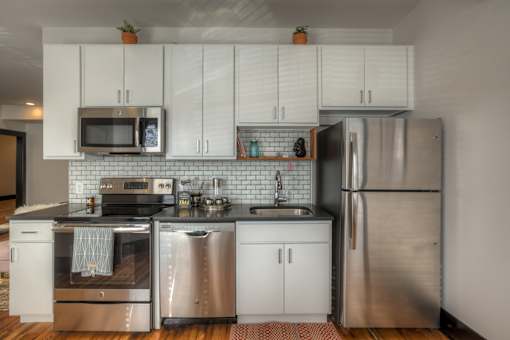 A kitchen with white cabinets and stainless steel appliances.