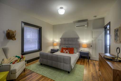 A bedroom with a bed, nightstands, and a window.