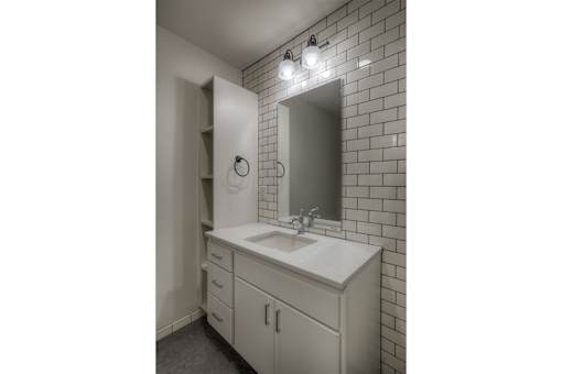 A bathroom with a white sink and a mirror above it.