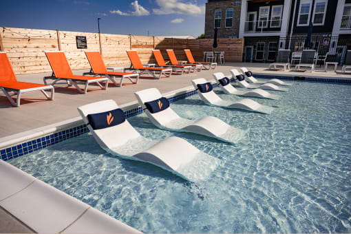 a reflection of lounge chairs in a pool of water