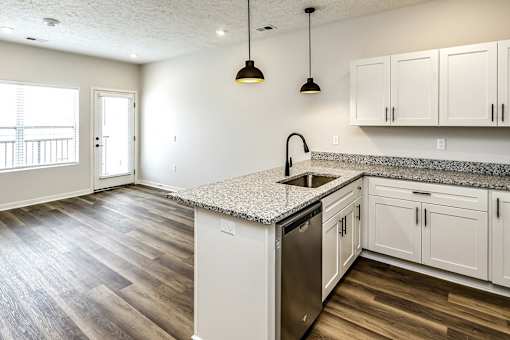 A kitchen with a granite countertop and wooden flooring.