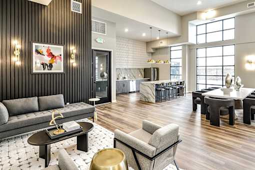 A modern living room with a grey sofa, a coffee table, and a dining table.