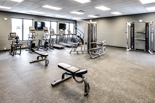 a large fitness room with cardio equipment and weights