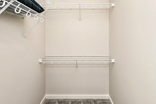 A white closet with a shelf and a hanging rod.