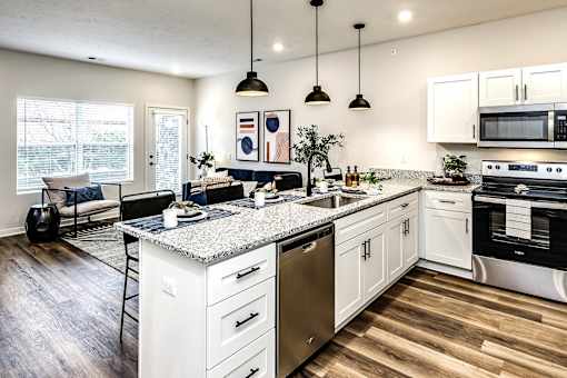 A modern kitchen with white cabinets and a granite countertop.