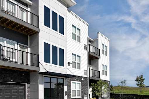 A modern two-story building with balconies and large windows.