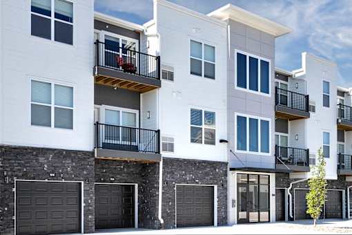 A row of modern townhouses with balconies and garages.