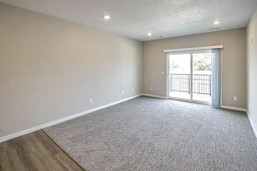 Living rooms with plush carpet at Logan Creek Apartments in Wakefield, NE