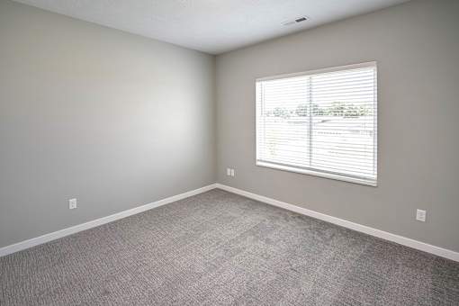 Bedroom with plush carpet at Logan Creek Apartments in Wakefield, NE
