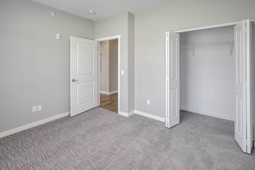 an empty bedroom with a closet and an open door