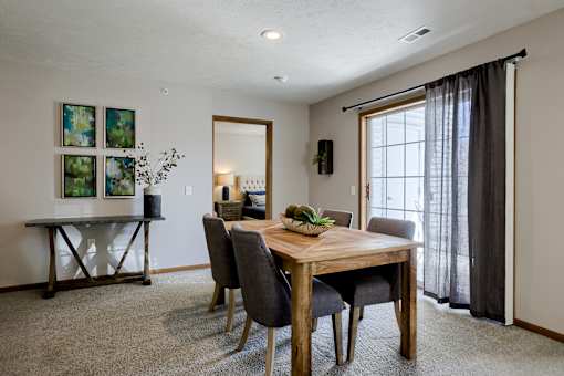 A dining room with a wooden table and chairs.